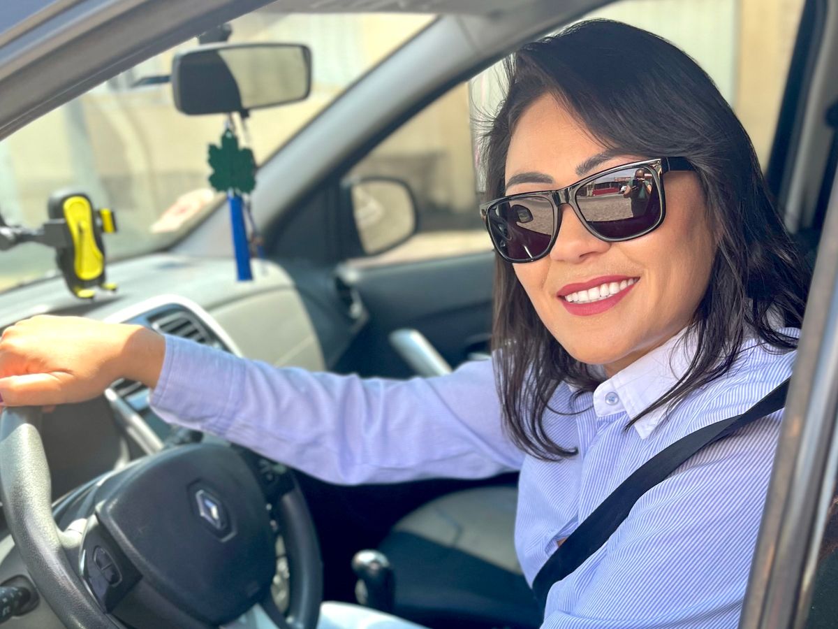 Karine, da HabilitaPro, ao volante de um carro
